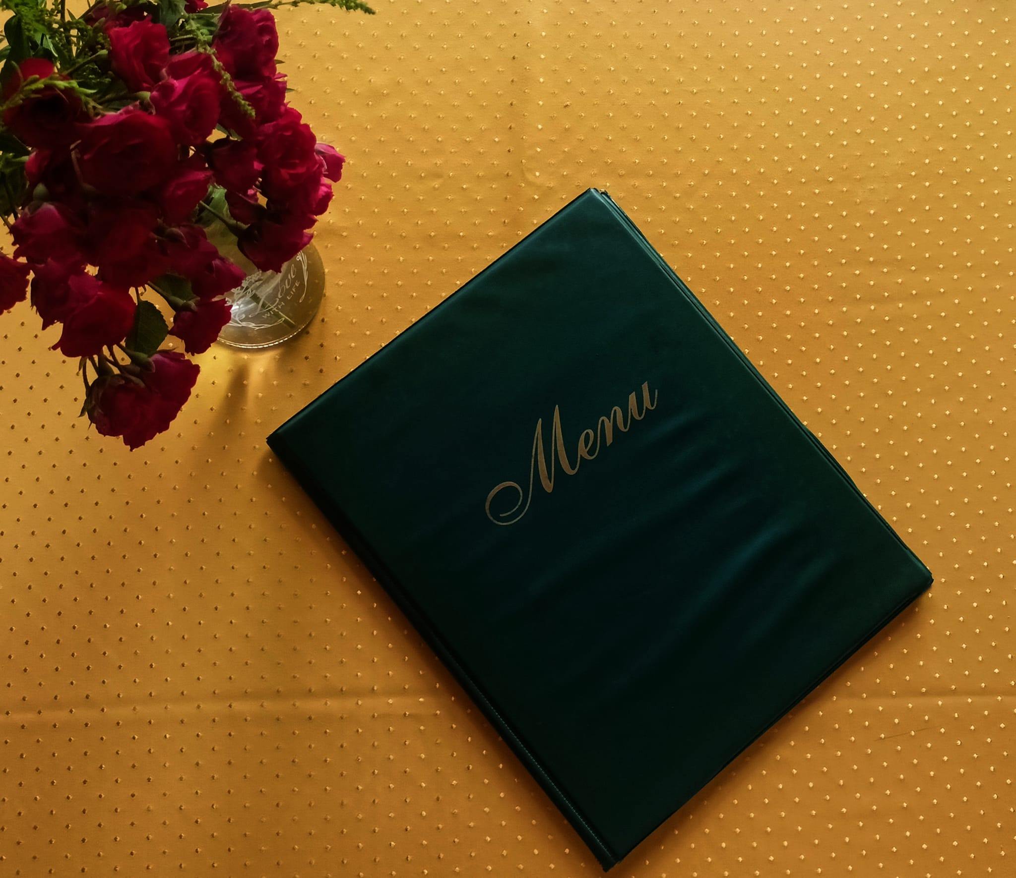 the menu on a table near a rose